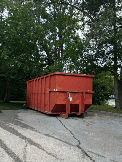 Large red roll-off dumpster placed in a parking lot in Guelph
