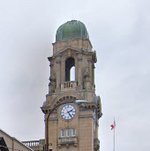Clock tower atop Brantford City Hall with a green dome and Canadian flag