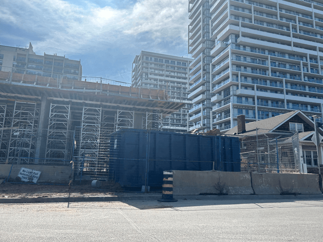 Large blue construction dumpster on an urban job site with high-rise buildings