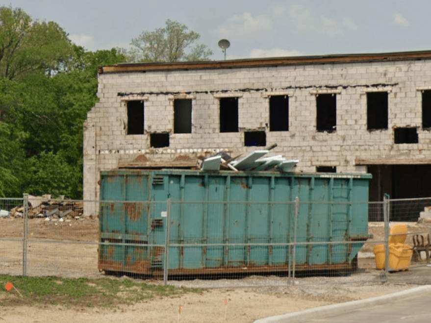 Roll-off dumpster truck delivering a blue bin in Guelph Ontario